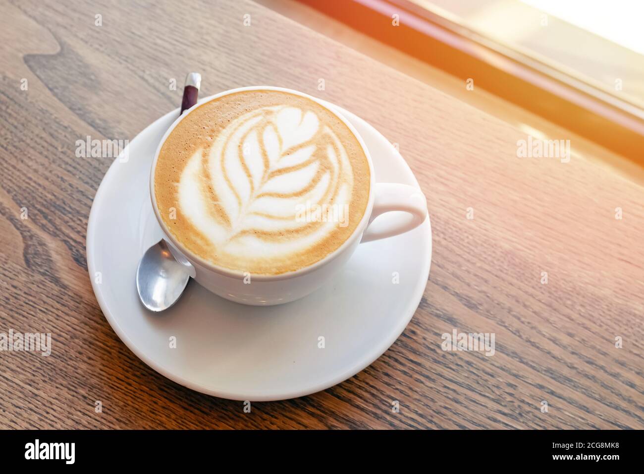 Vinaigrette au cappuccino chaud avec latte en forme de latte sur une table en bois Banque D'Images