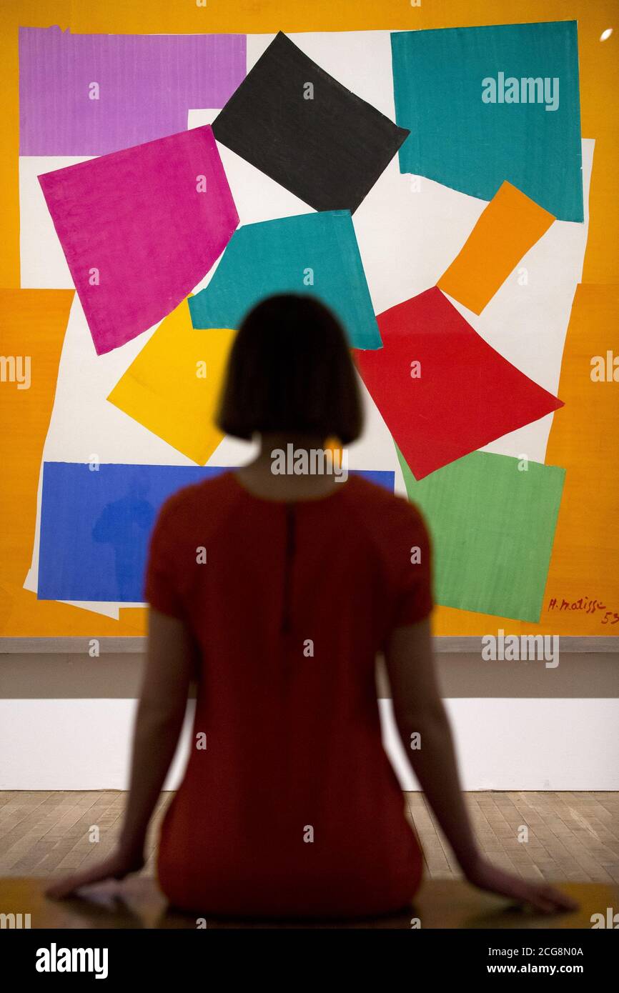 Un assistant de galerie pose devant 'The Snail 1953' par Henri Matisse à l'exposition Cut-outs du Tate Modern, Londres. Banque D'Images Un assistant de galerie pose devant 'The Snail 1953' par Henri Matisse à l'exposition Cut-outs du Tate Modern, Londres. Banque D'Images
