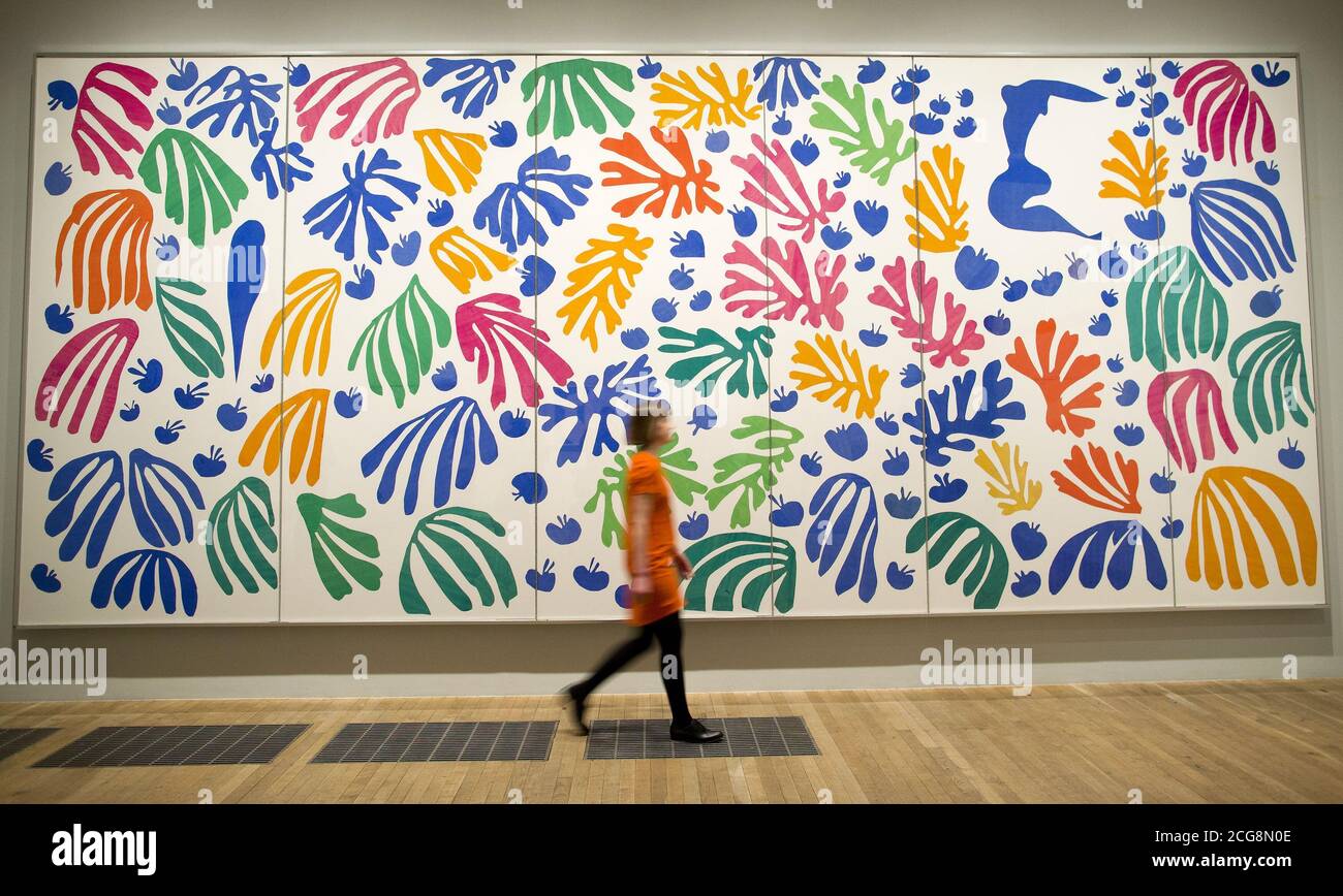 Un assistant de galerie passe devant "le Parakeet et la Sirène 1952" par Henri Matisse à l'exposition Cut-outs au Tate Modern, Londres. Banque D'Images Un assistant de galerie passe devant "le Parakeet et la Sirène 1952" par Henri Matisse à l'exposition Cut-outs au Tate Modern, Londres. Banque D'Images
