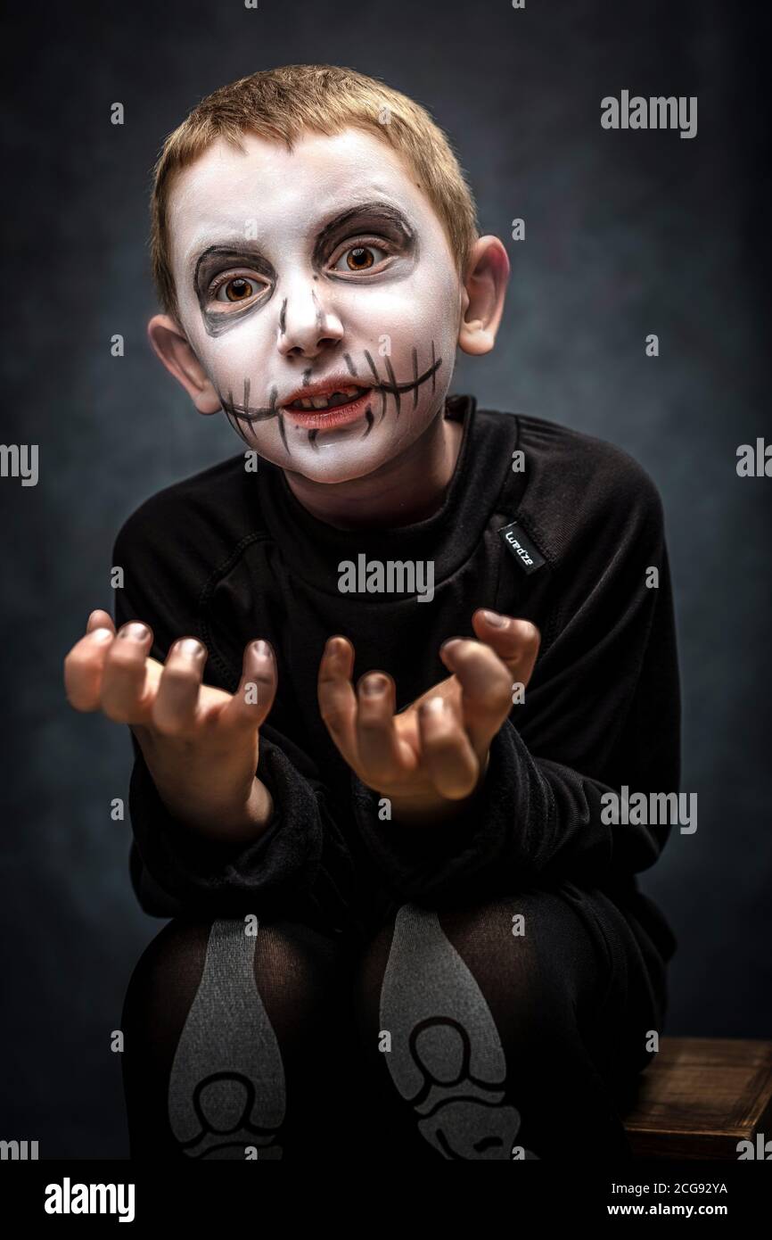 enfant habillé comme squelette dans une posture effrayante. costume d'halloween, photo en studio Banque D'Images