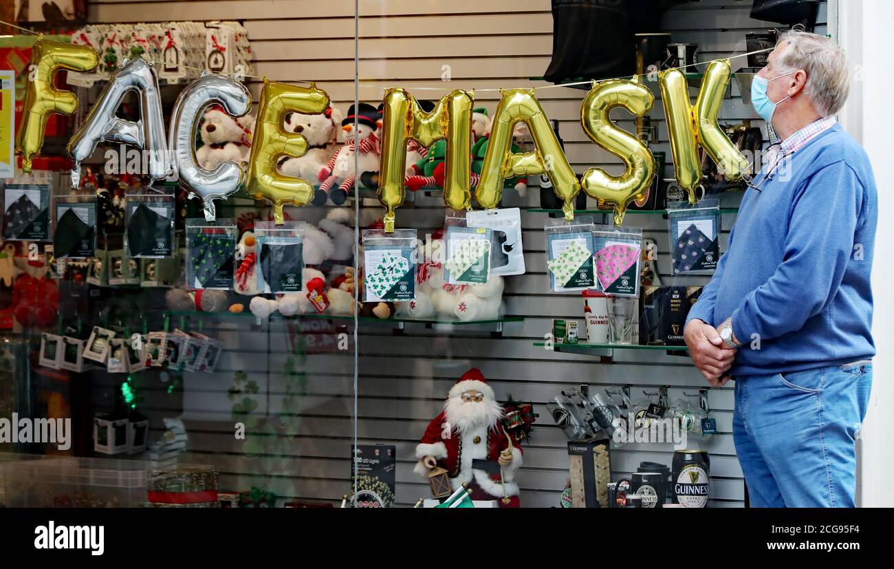 Un homme regarde dans un magasin vendant des masques de visage dans le centre de Dublin. L'incapacité du gouvernement à communiquer correctement son message de santé publique Covid-19 a été décrit comme un « abus de pouvoir ». Banque D'Images