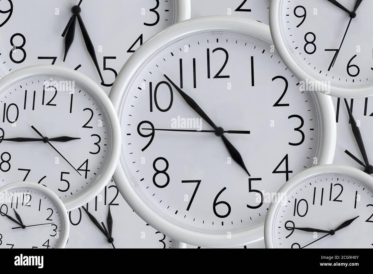 Arrière-plan de l'ensemble d'horloges de bureau rondes analogiques blanches de différentes tailles montrant différentes heures Banque D'Images