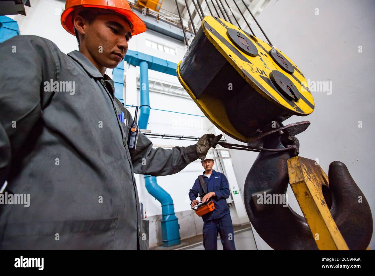 Travailleurs utilisant une grue sur une usine de métallurgie du titane. Pour charger l'éponge en titane dans le four à arc sous vide. Banque D'Images