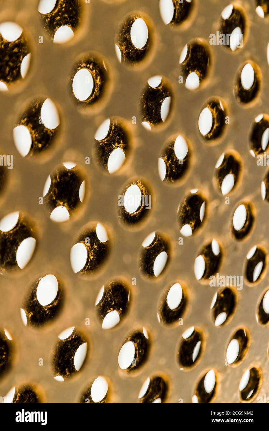 Gros plan de métal extérieur doré recouvert de petits trous. Banque D'Images