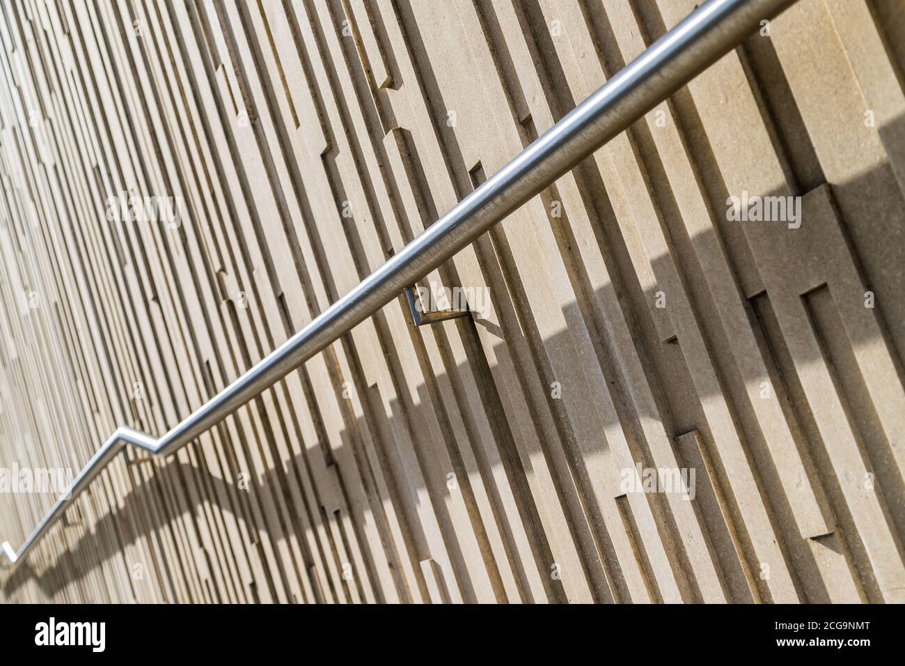 Rail en zigzag vu à Liverpool devant des motifs verticaux sur un mur. Banque D'Images