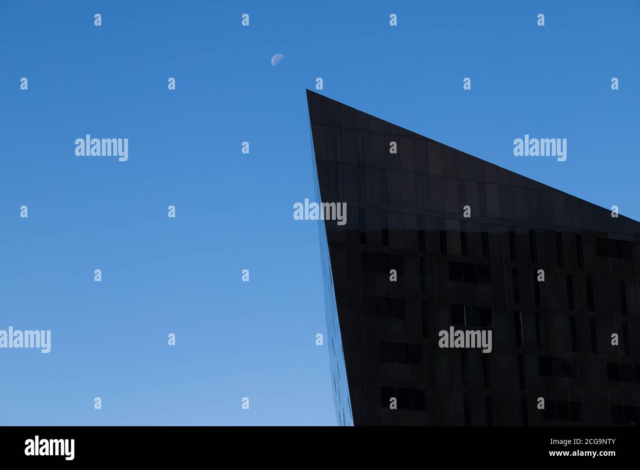 Le bord pointu d'un bâtiment du complexe de l'île Mann pointe vers la lune à Liverpool en septembre 2020. Banque D'Images