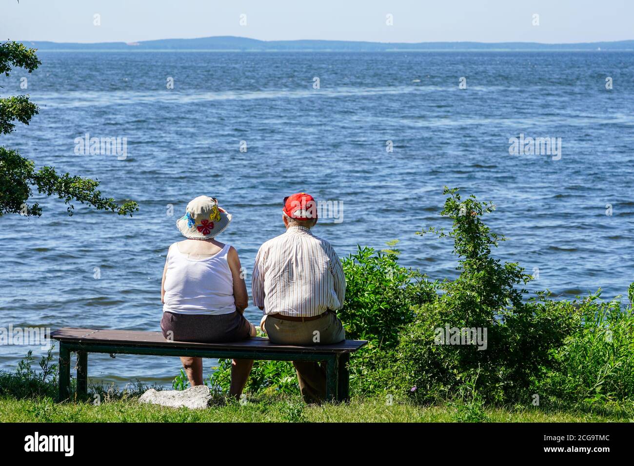 une vieille femme et un homme s'assoient sur un banc par la mer et regarder dans la distance Banque D'Images