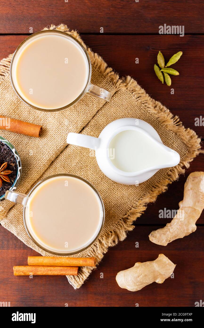 Thé de chaï au masala sur le burlap. Boisson traditionnelle indienne - thé masala avec épices sur fond de bois. Vue de dessus Banque D'Images