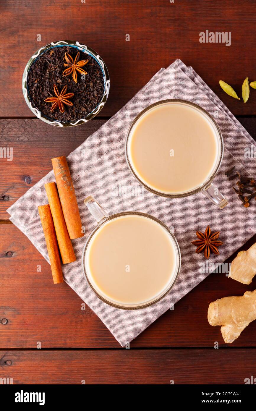 Thé au chaï masala sur la serviette en lin. Boisson traditionnelle indienne - thé masala avec épices sur fond de bois. Vue de dessus Banque D'Images