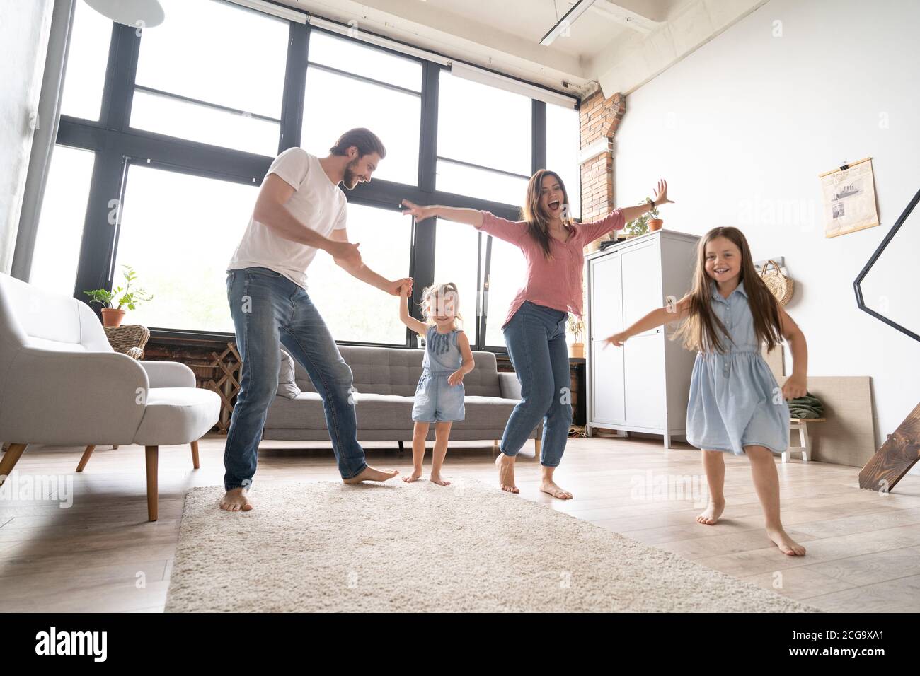 bonne famille mère père et enfant fille dansant à la maison. Banque D'Images