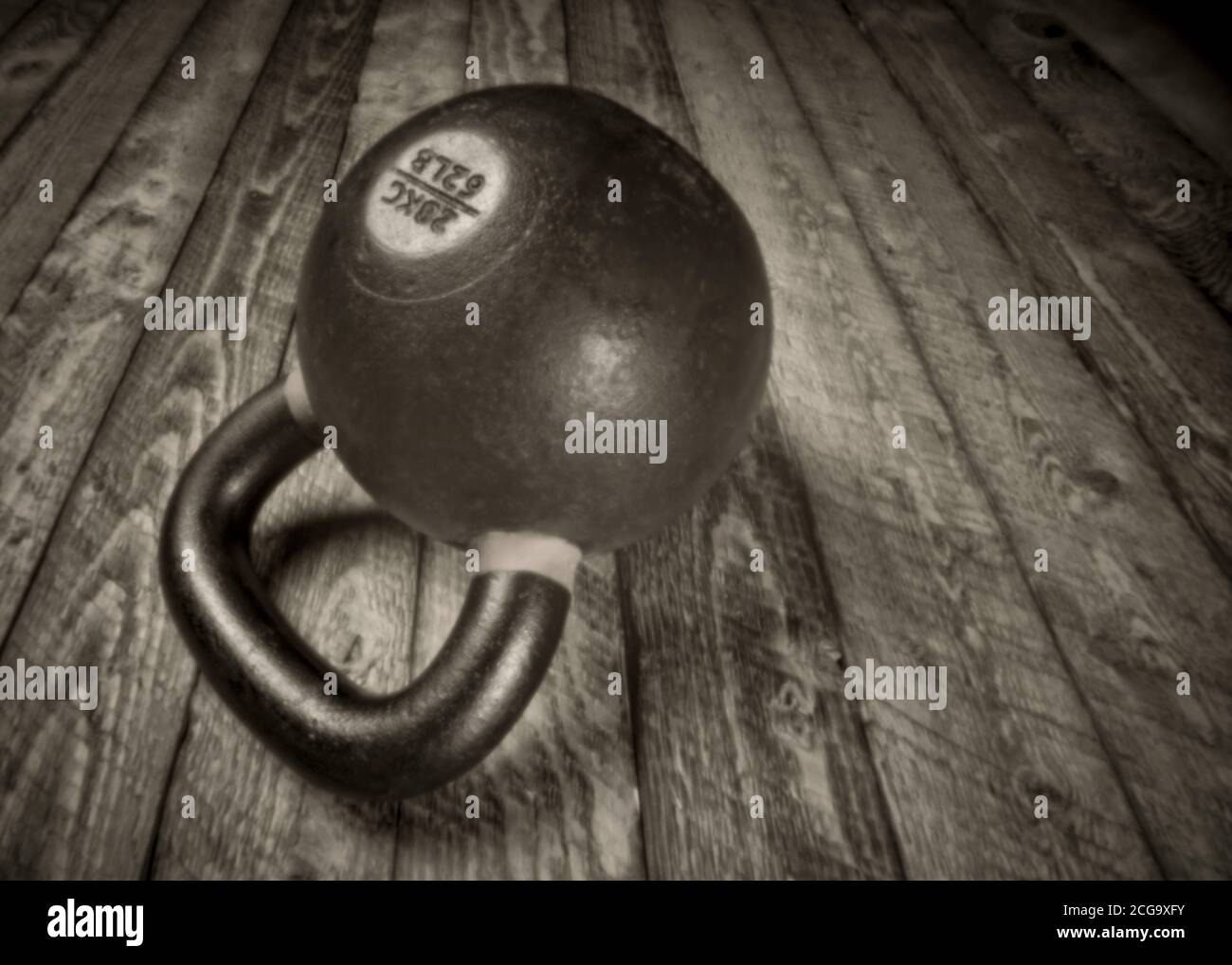 kettlebell en fer lourd sur fond de bois rustique - concept de fitness, mise au point douce image noir et blanc prise avec un appareil photo à trou d'épingle sans lensless Banque D'Images