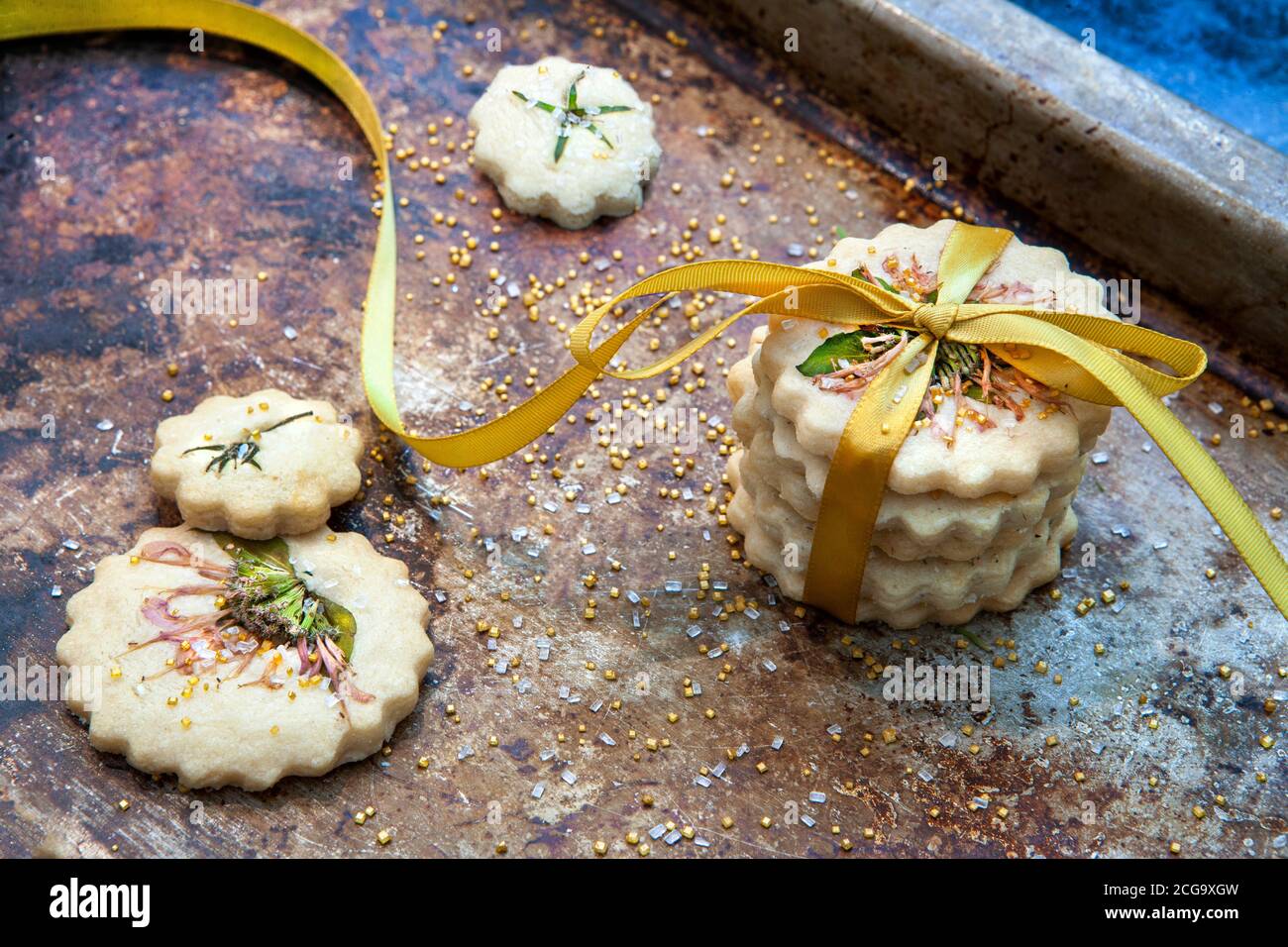 Petite pile de biscuits sablés avec noeud papillon, fleurs comestibles et sucre doré, vue en grand angle Banque D'Images