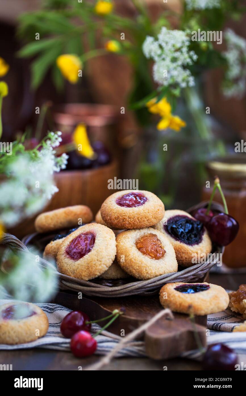 Biscuits aux amandes avec imprimé pouces et confiture sur fond de bois rustique Banque D'Images