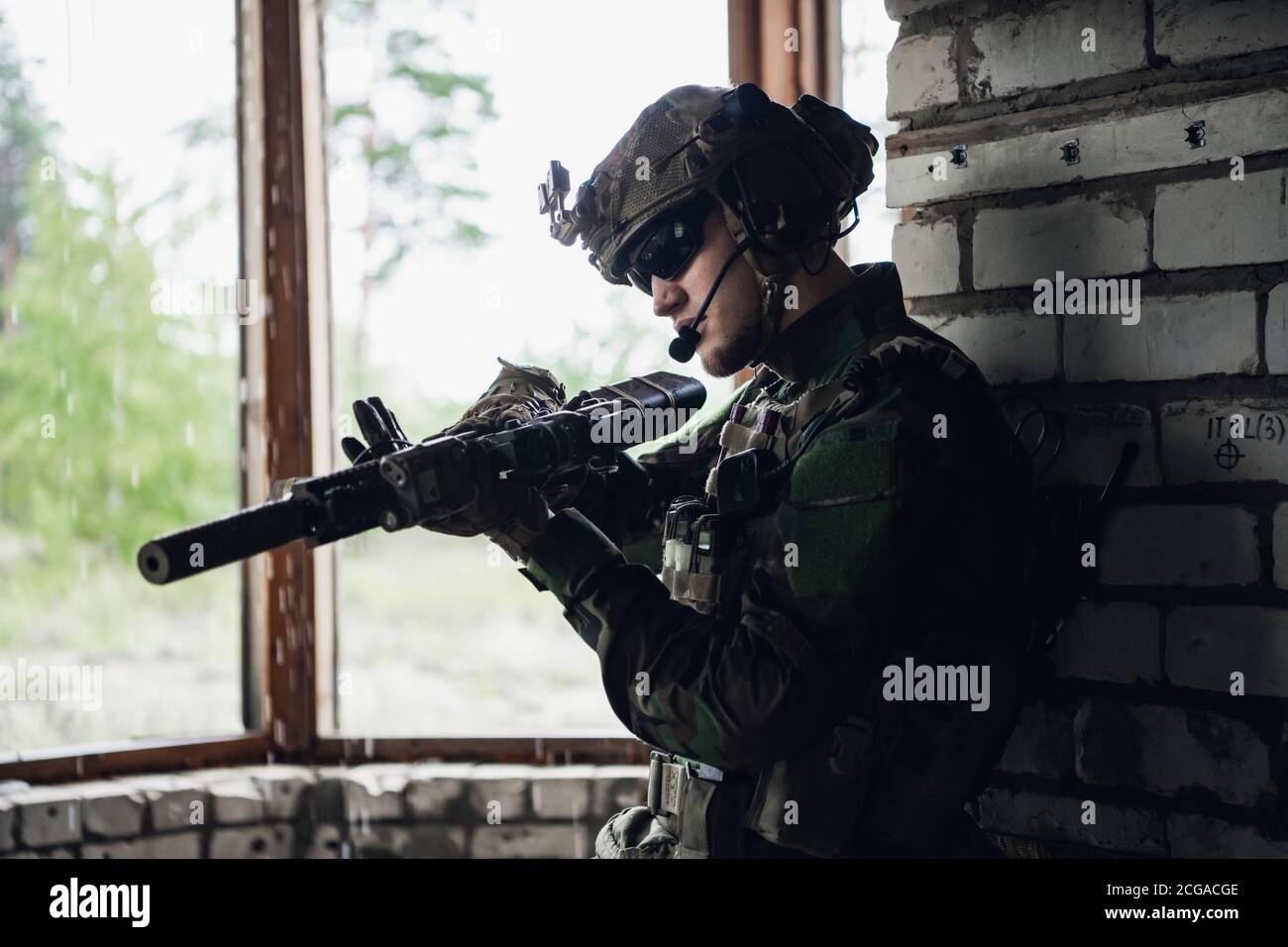 Inspection des armes en attendant sur place. L'homme militaire vérifie sa carabine d'assaut en préparation à l'opération. Banque D'Images