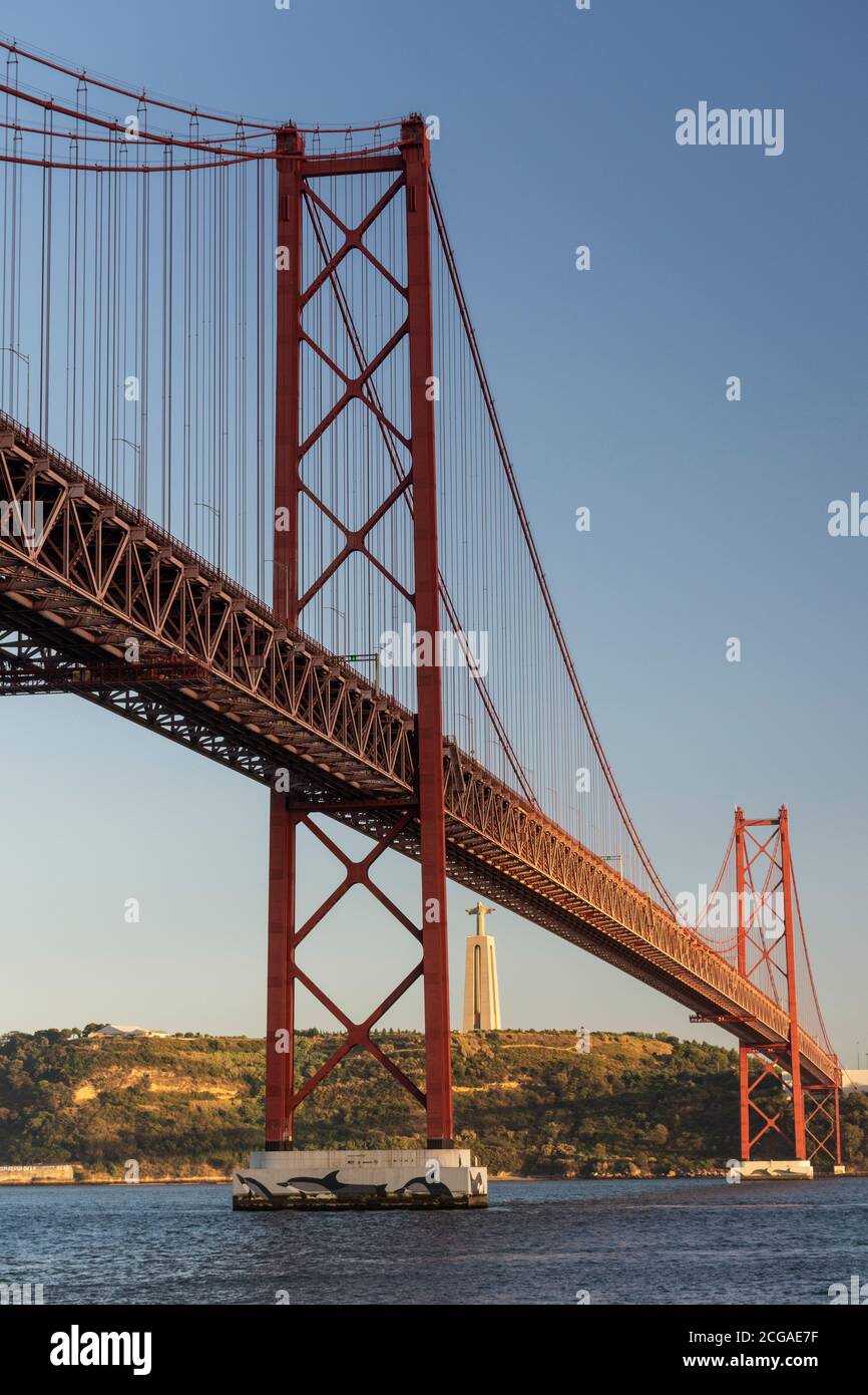 Belle vue sur le pont 25 de Abril au-dessus de la rivière Tejo et la statue de Cristo Rei au coucher du soleil, centre de Lisbonne, Portugal Banque D'Images