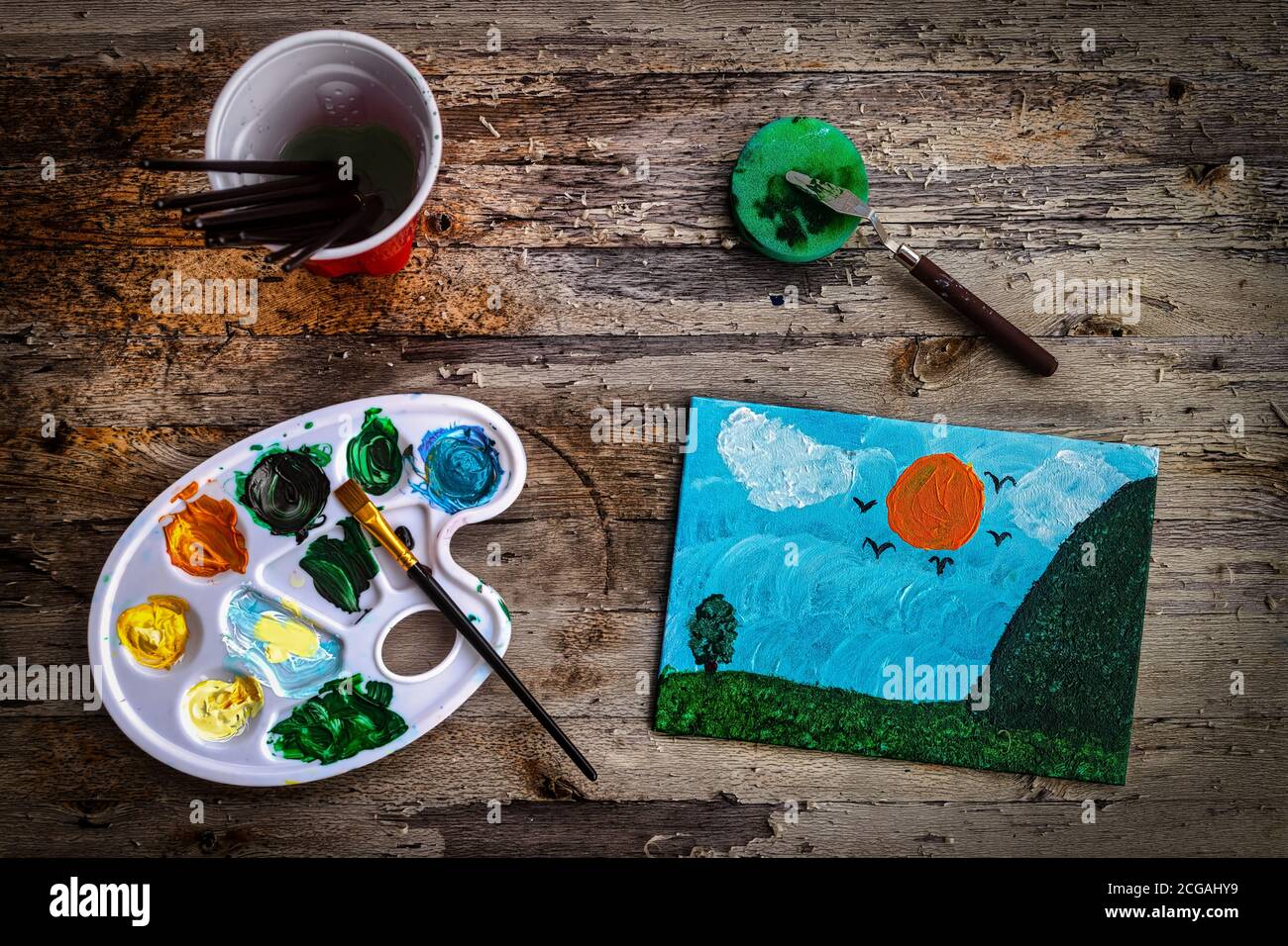 Mes filles sont les dernières œuvres d'art, avec ses pinceaux, assis sur la table de notre patio. Banque D'Images