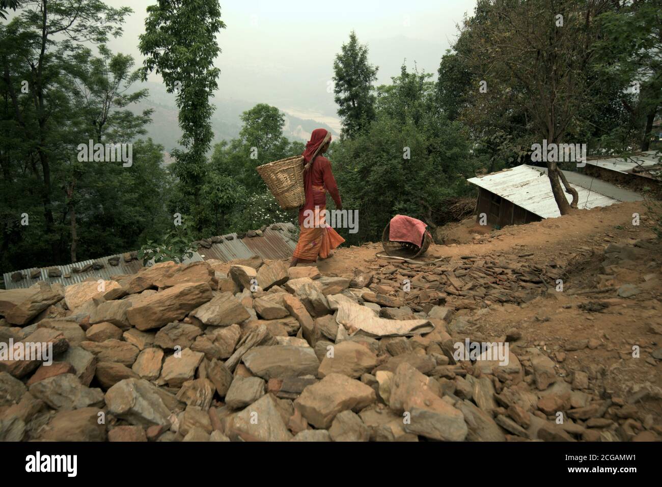 Une femme marchant dans le village de Mandan de Chandeni (Chandani) qui a été fortement touchée par les tremblements de terre et les glissements de terrain de 2015 à Kavrepalanchok, au Népal. Banque D'Images