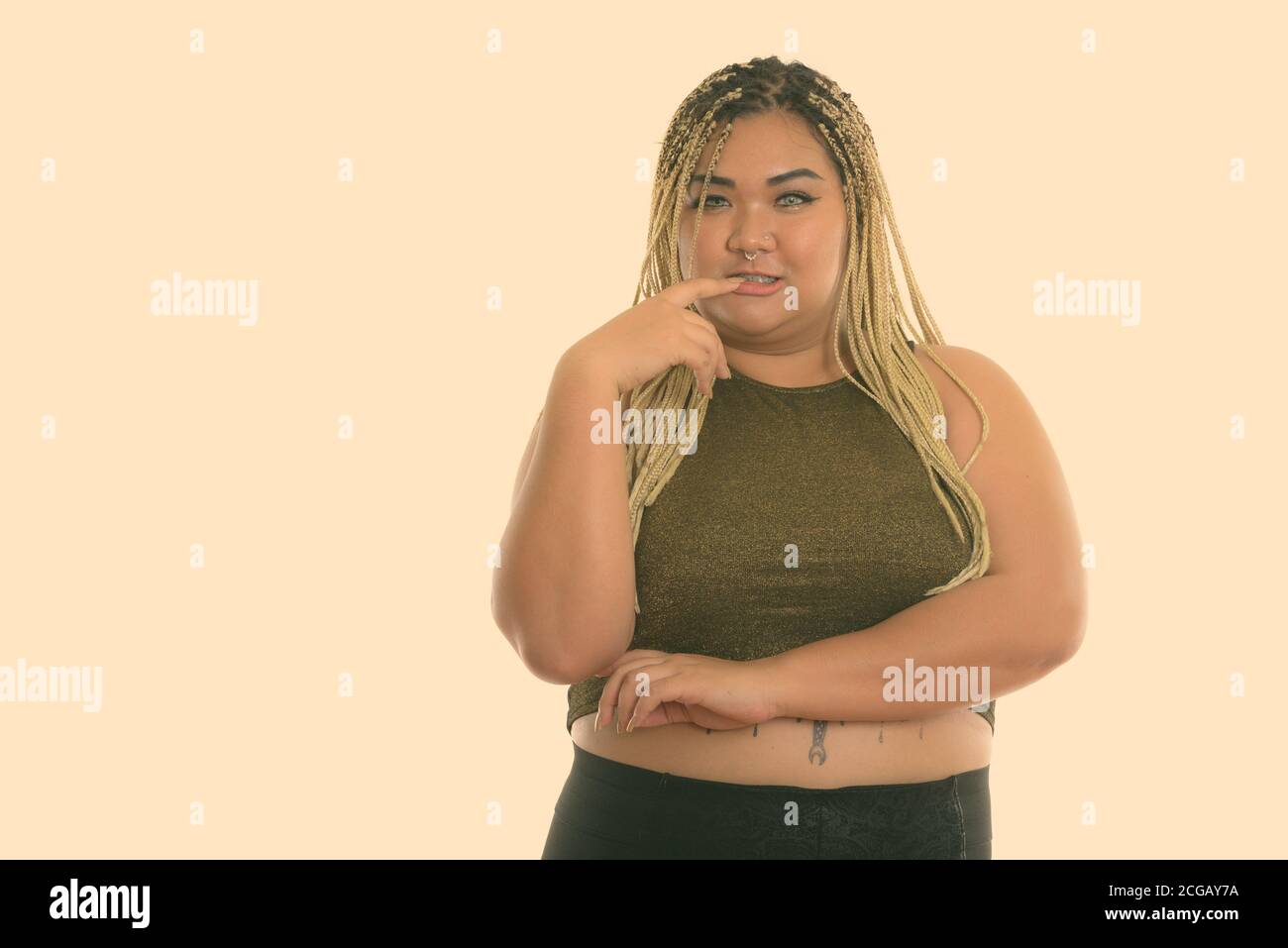 Studio shot of young Asian woman biting fingernail gras Banque D'Images