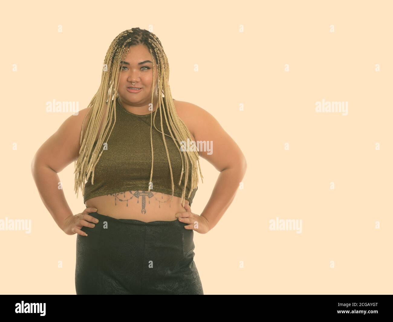 Studio shot of young woman smiling Asian fat heureux avec les mains sur les hanches Banque D'Images