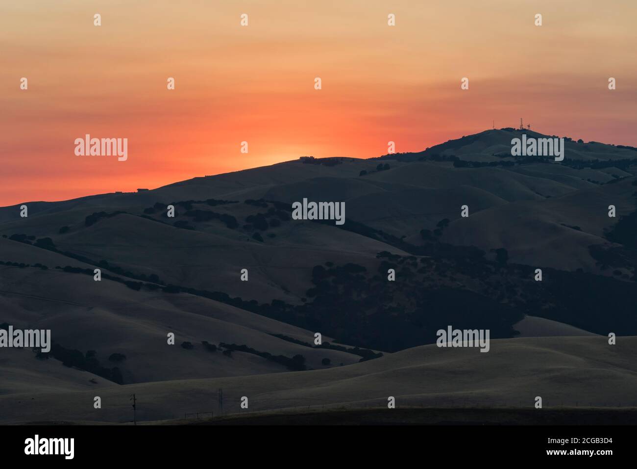 Fumée des sauvages proches en couleur le coucher de soleil sur la chaîne Diablo depuis le Brushy Peak du parc régional d'East Bay à Livermore, en Californie. Banque D'Images