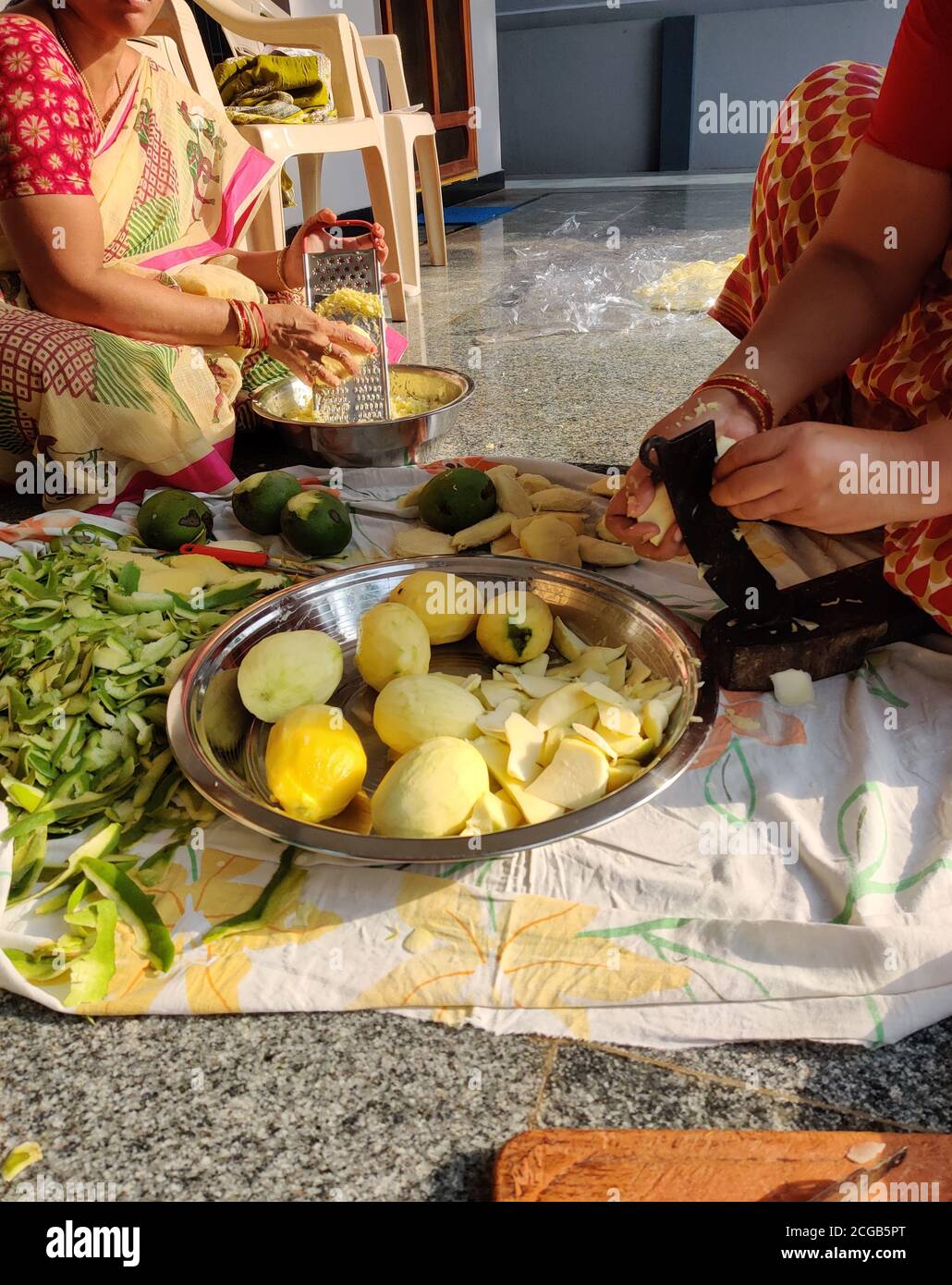 Les femmes indiennes se sentent dans la coupe de mangue brute pour faire de la mangue Pickle une recette spéciale indienne Banque D'Images