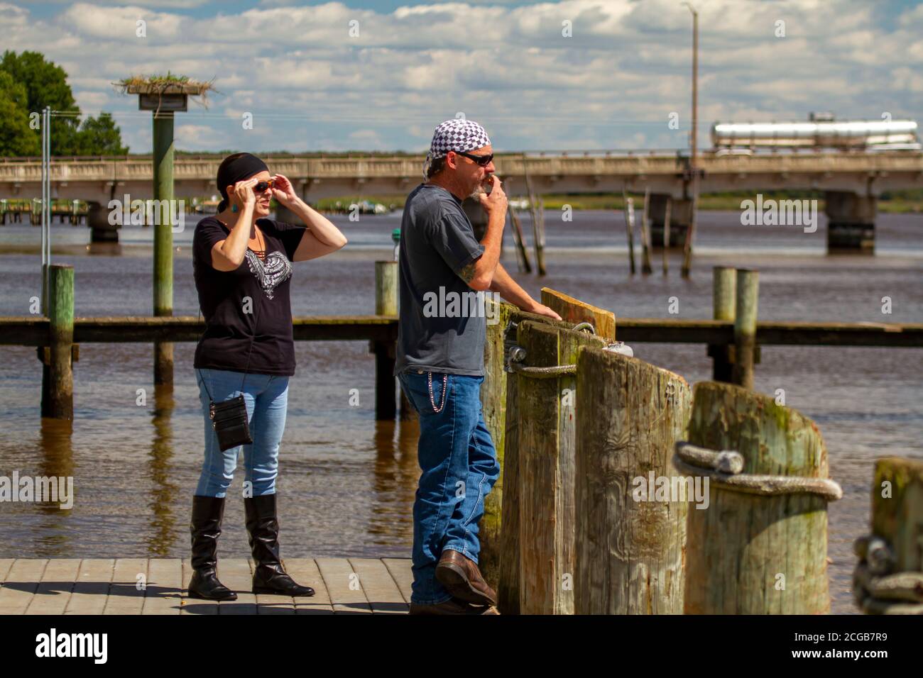 Chestertown, MD, USA, 08/30/2020: Un rocker d'âge moyen est debout sur le quai près de la rivière Chester. Ils portent tous les deux bandanna, lunettes de soleil, jeans et le le Banque D'Images