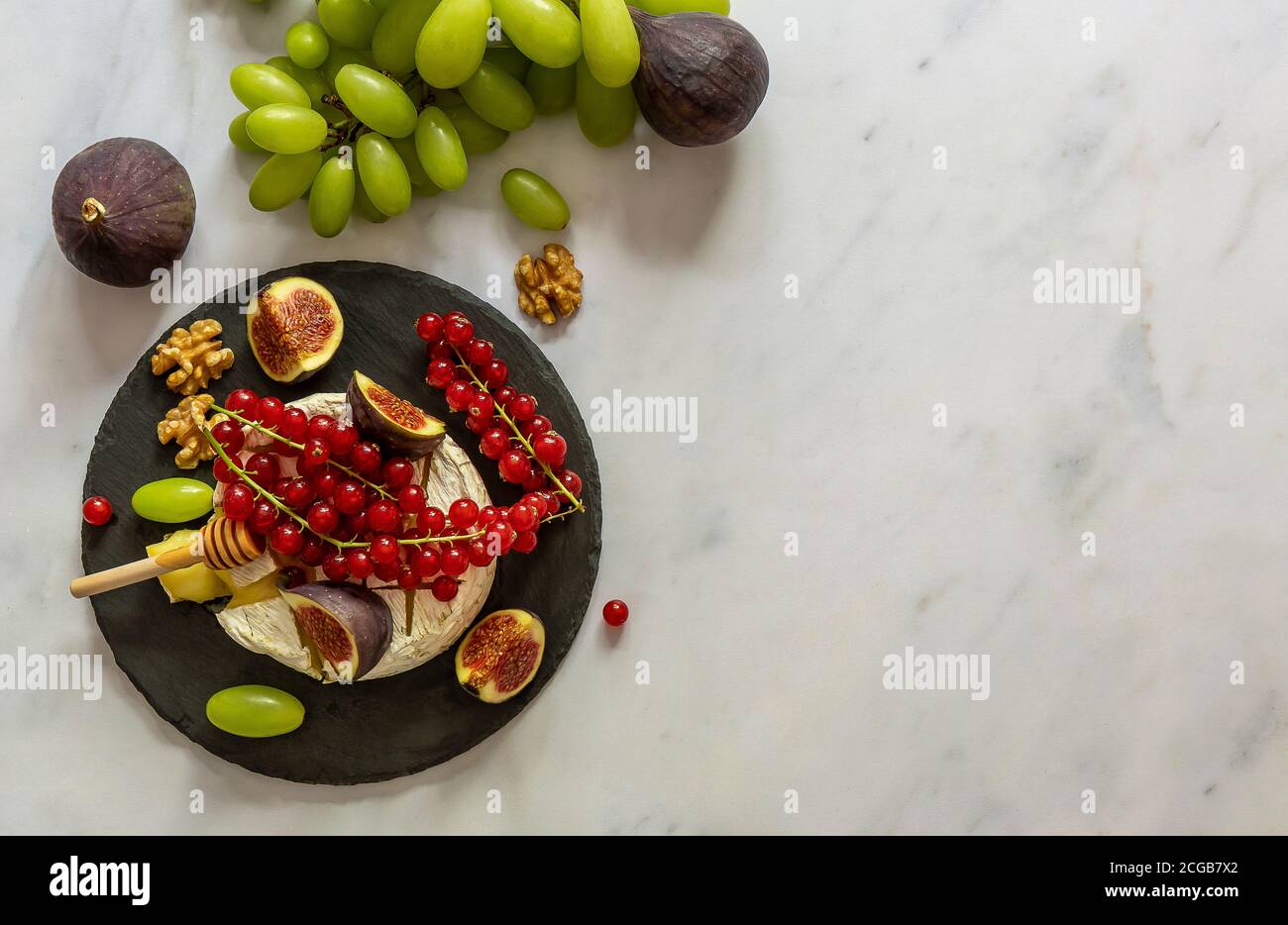 Fromage Camembert cuit au four avec miel, fruits, noix et baies Banque D'Images