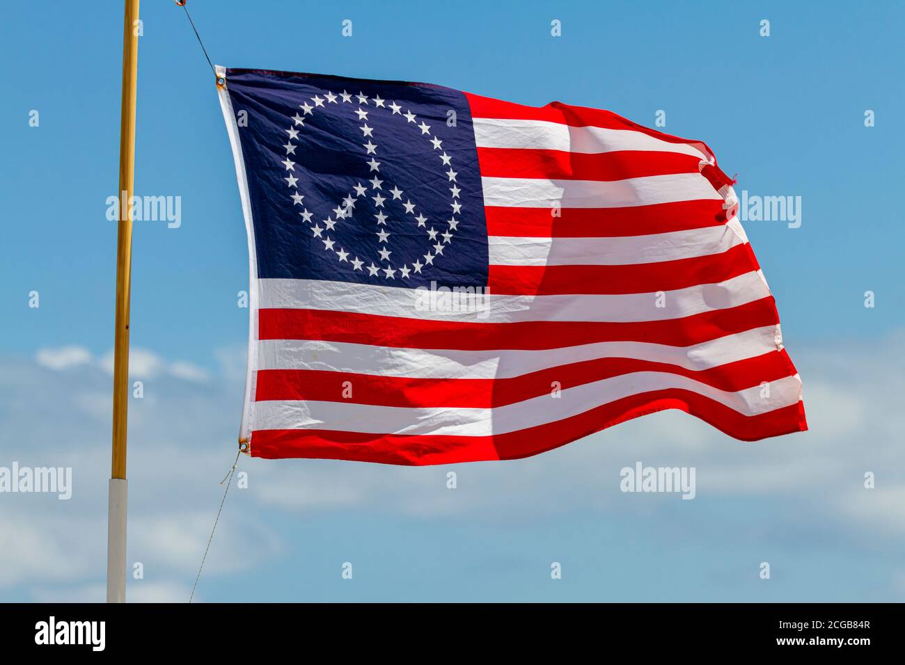 Un drapeau des États-Unis avec des étoiles et des rayures, orienté en forme de signe de paix. Ce drapeau agite sur un poteau par un jour venteux Banque D'Images