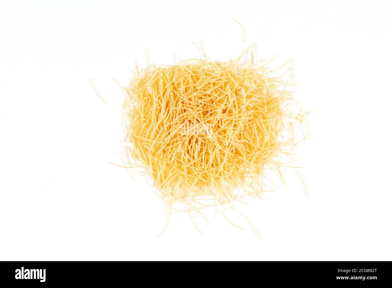 Vue de dessus des pâtes vermicelles non cuites sur fond blanc. Pâtes vermicelles sèches non cuites Banque D'Images
