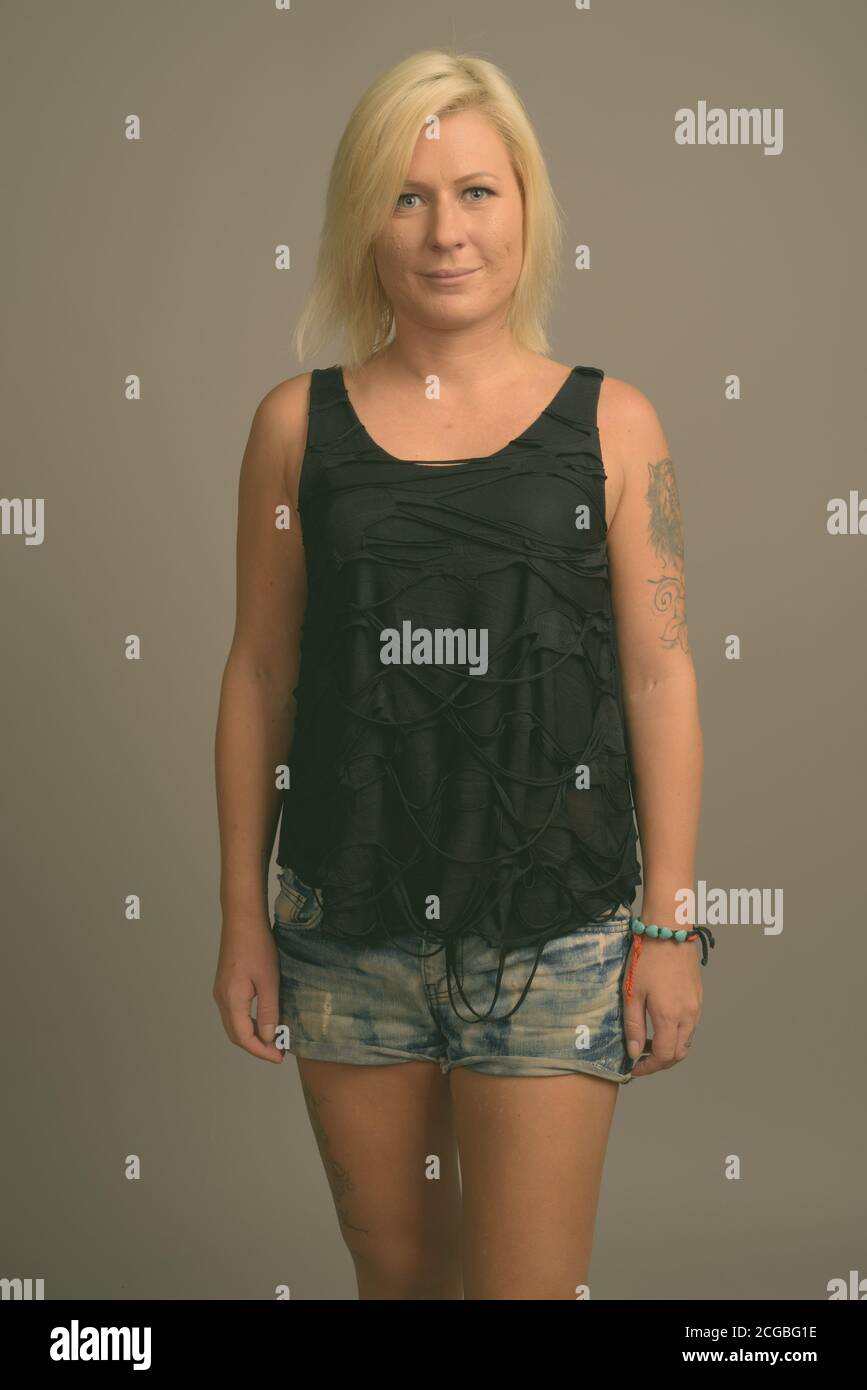 Femme aux cheveux blonds sur fond gris Banque D'Images