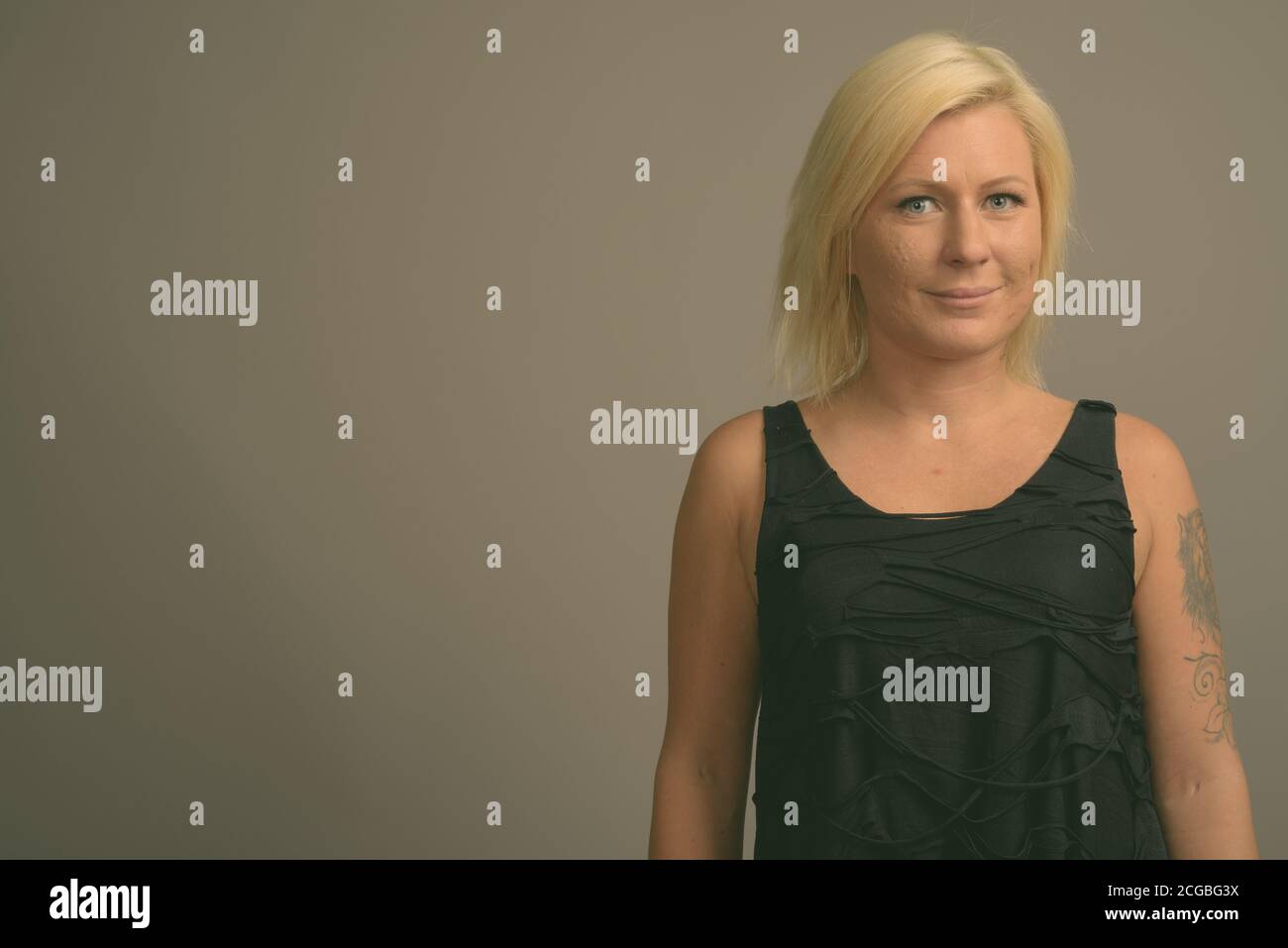 Femme aux cheveux blonds sur fond gris Banque D'Images