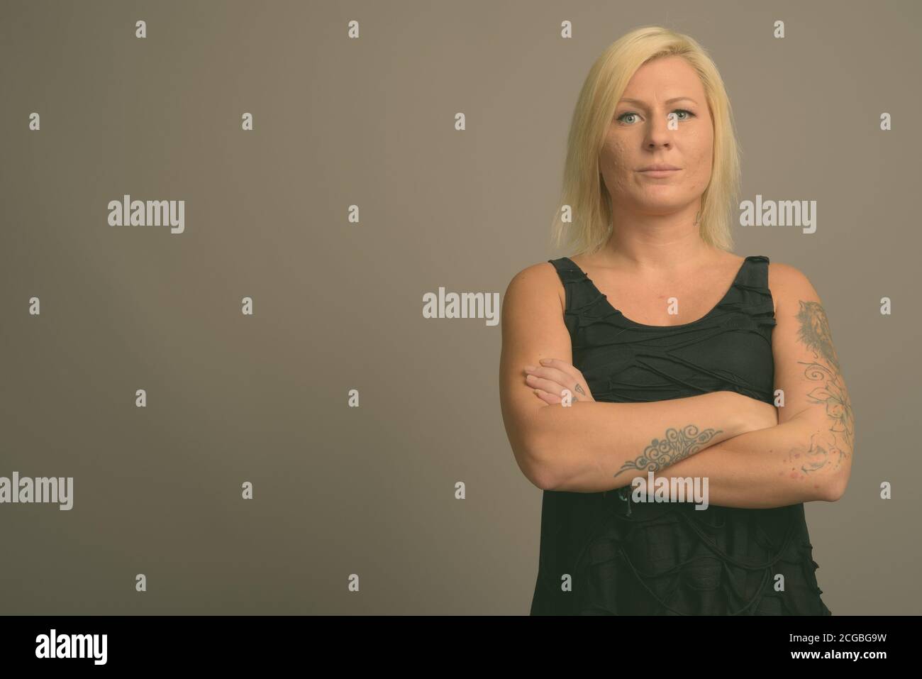 Femme aux cheveux blonds sur fond gris Banque D'Images