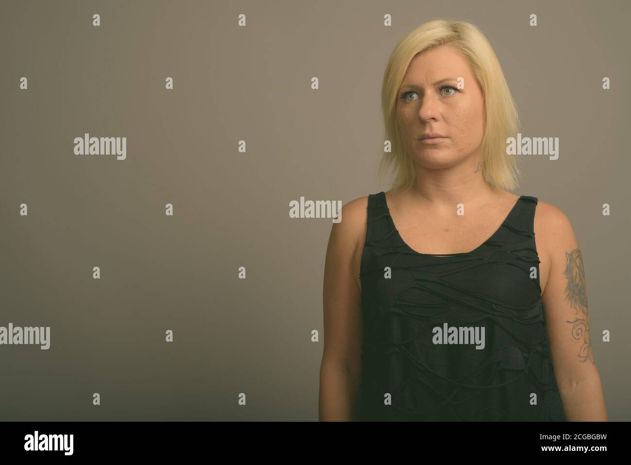 Femme aux cheveux blonds sur fond gris Banque D'Images