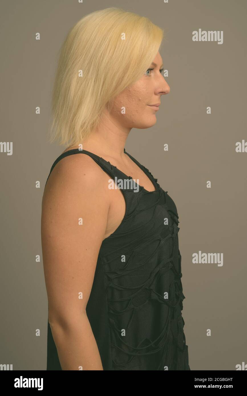 Femme aux cheveux blonds sur fond gris Banque D'Images