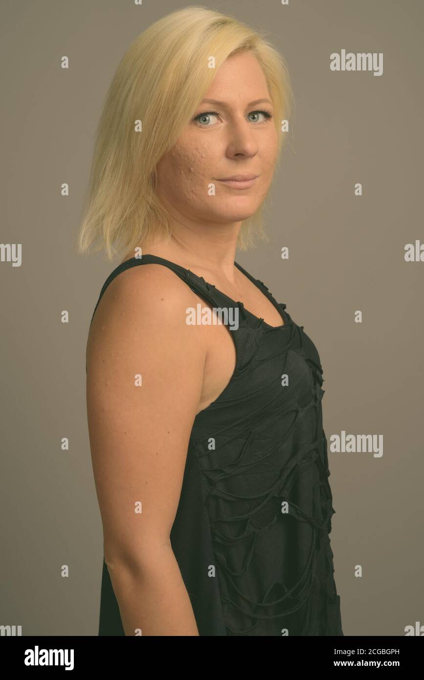 Femme aux cheveux blonds sur fond gris Banque D'Images