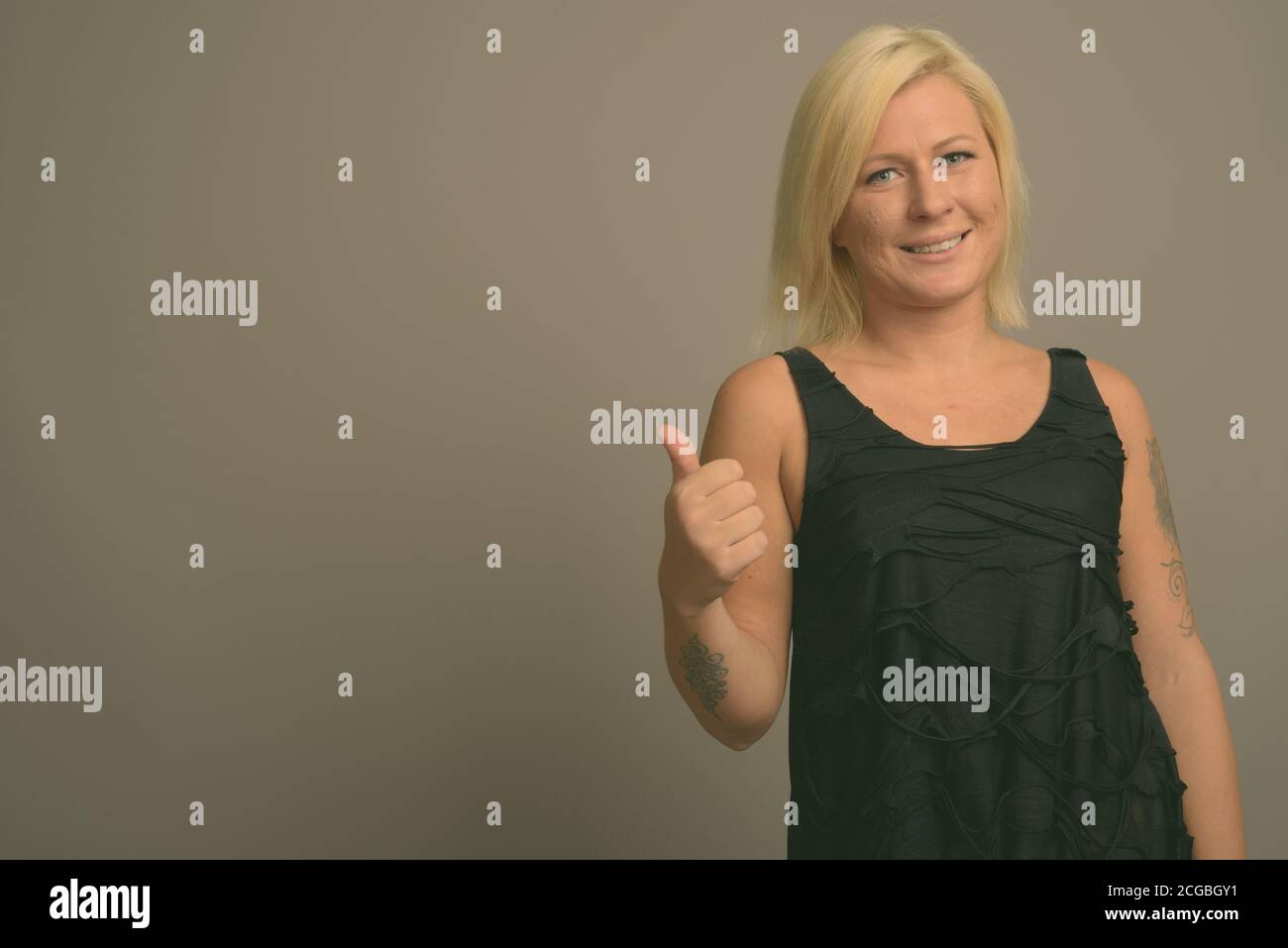 Femme aux cheveux blonds sur fond gris Banque D'Images