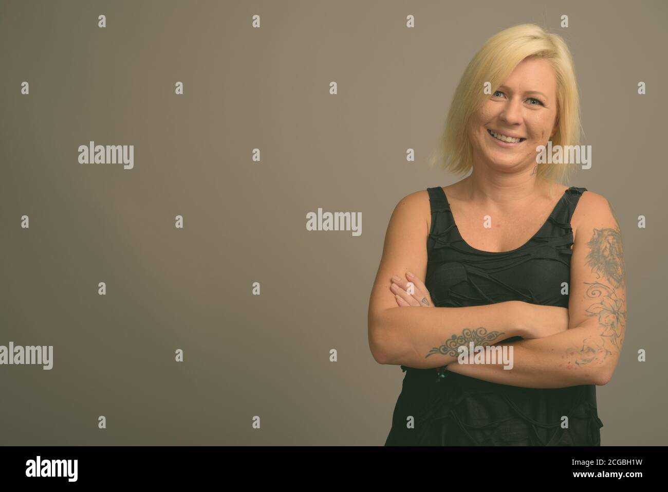 Femme aux cheveux blonds sur fond gris Banque D'Images