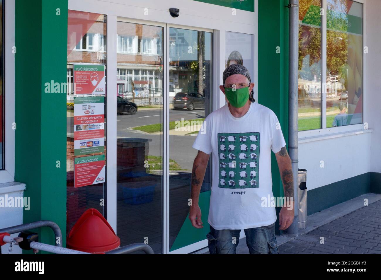 homme âgé masqué debout à l'extérieur du supermarché portant une chemise de mouton en protestation passive contre le port forcé du masque lenti zala comté hongrie Banque D'Images