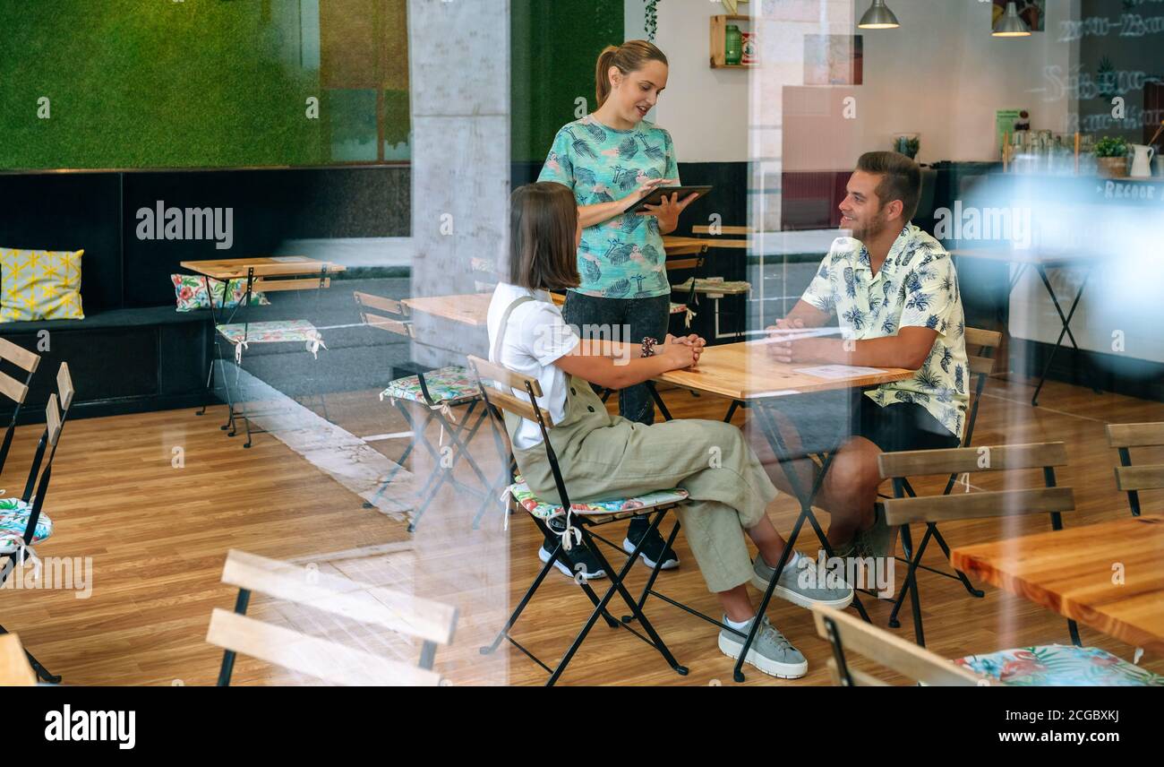 Serveuse prenant la commande du client avec une tablette Banque D'Images