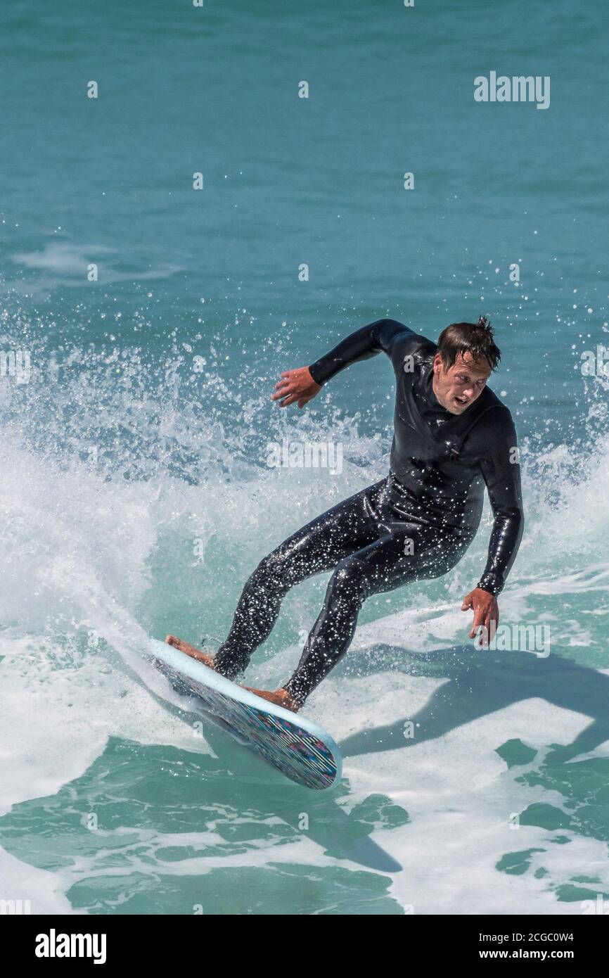 Une action spectaculaire en tant que surfeur fait une vague à Fistral à Newquay, dans Cornwall. Banque D'Images