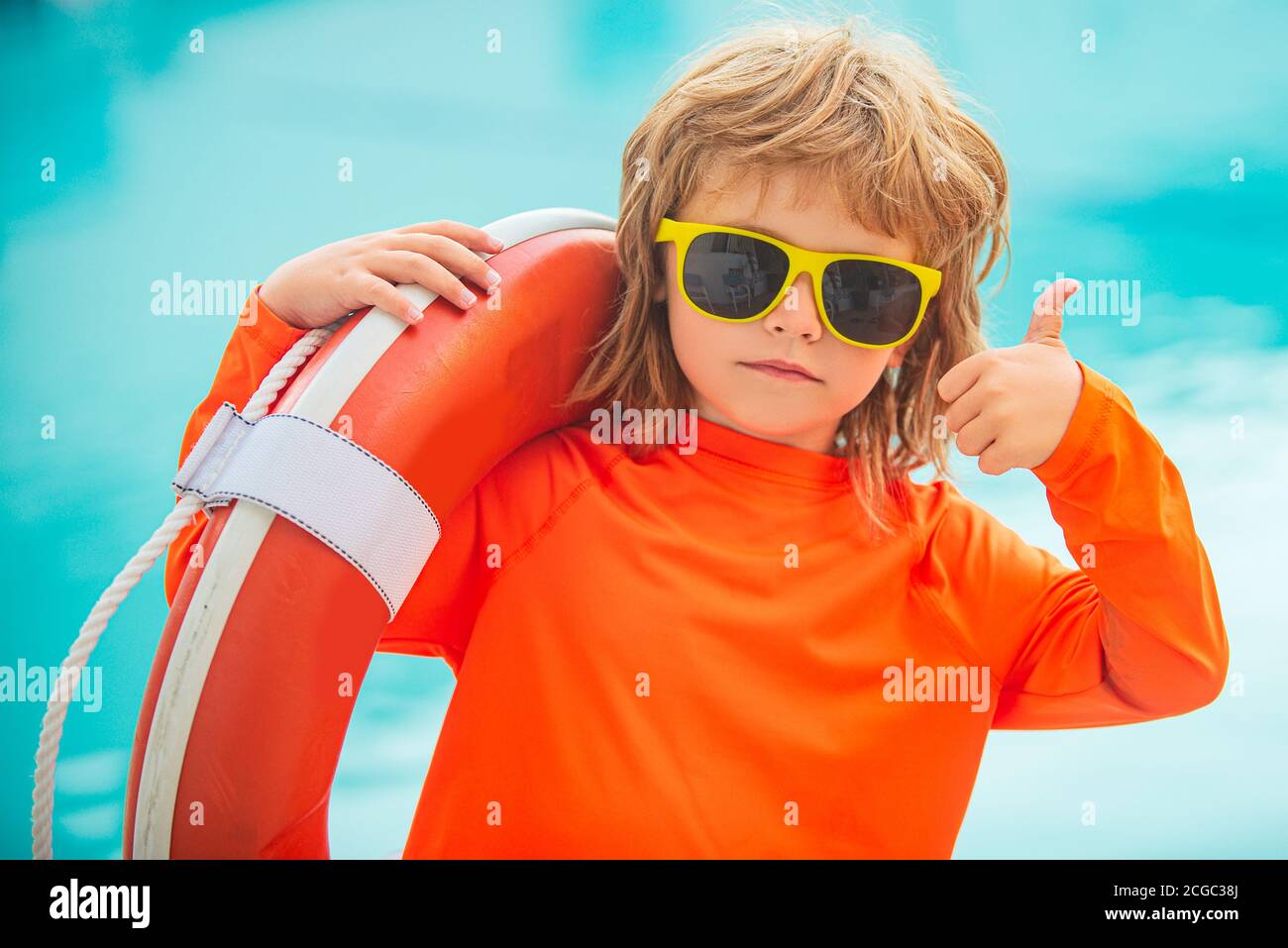 Enfant dans des lunettes de soleil sur la plage. Le maître-nageur de garçon  montre les pouces vers le haut, comme ok Photo Stock - Alamy