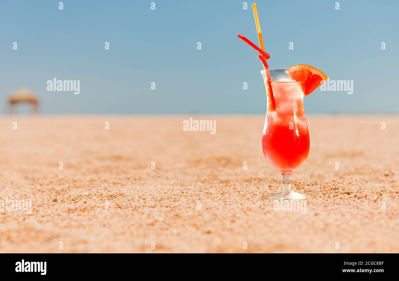 cocktail de pamplemousse rouge avec jus sur la plage de sable à paysage marin à l'horizon Banque D'Images