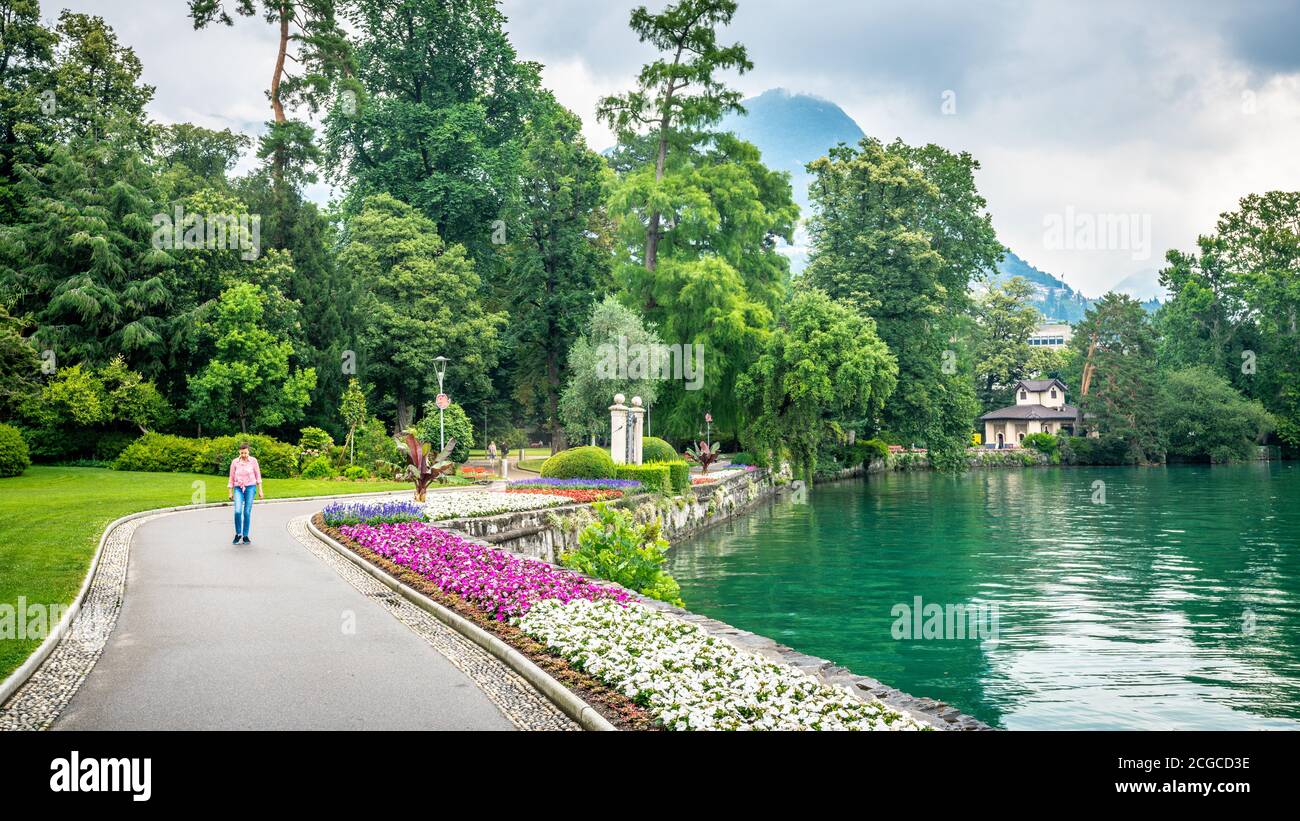 Lugano Suisse , 1er juillet 2020 : personne marchant dans le jardin public Parco Civico Ciani avec des fleurs le long des rives du lac de Lugano à Lugano Tessin Switze Banque D'Images