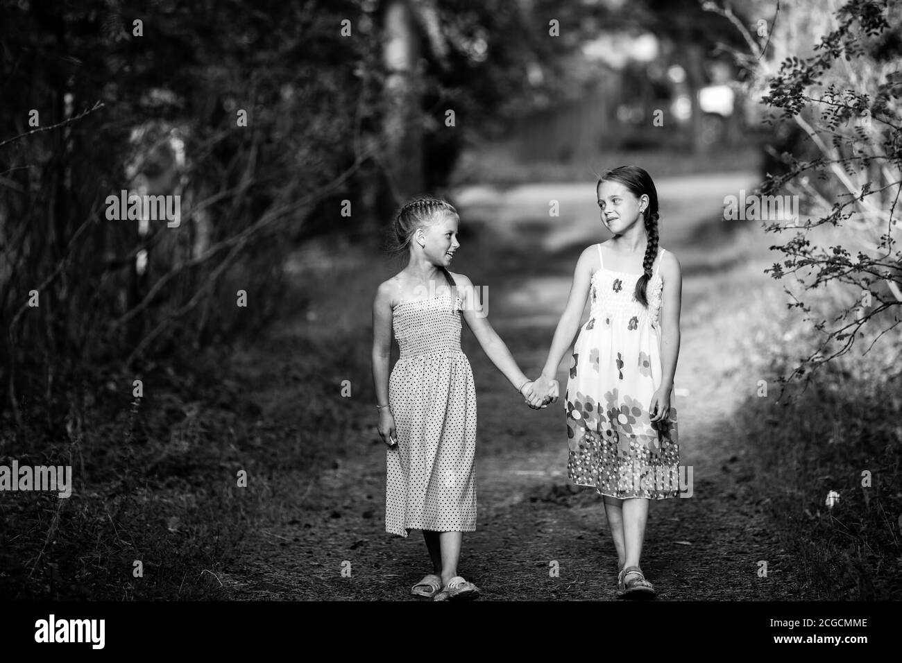 Deux filles de dix ans marchent dans la ruelle. Photo en noir et blanc. Banque D'Images