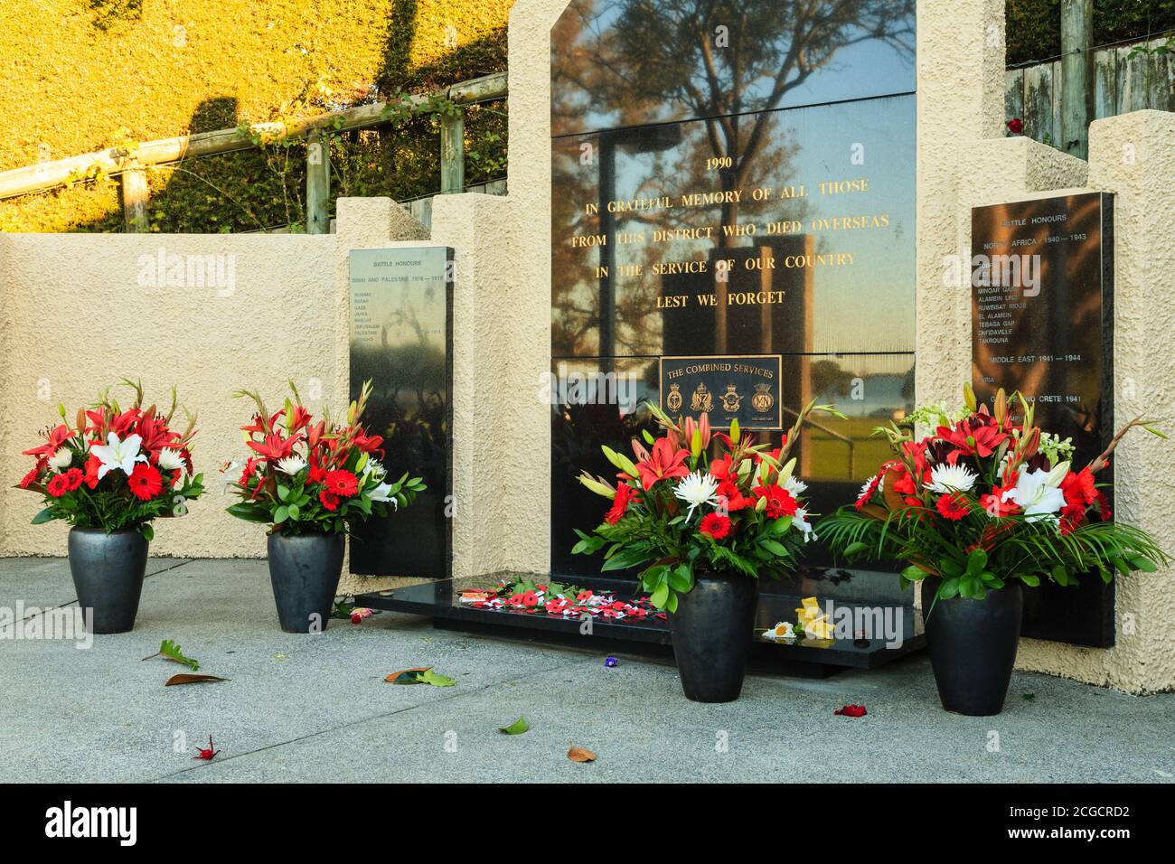 Fleurs disposées autour de la base d'un mémorial de guerre le jour d'Anzac. Memorial Park, Tauranga, Nouvelle-Zélande, avril 25 2018 Banque D'Images
