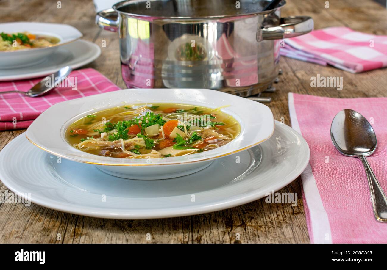 soupe de poulet table avec assiette, cuillère, pot Banque D'Images