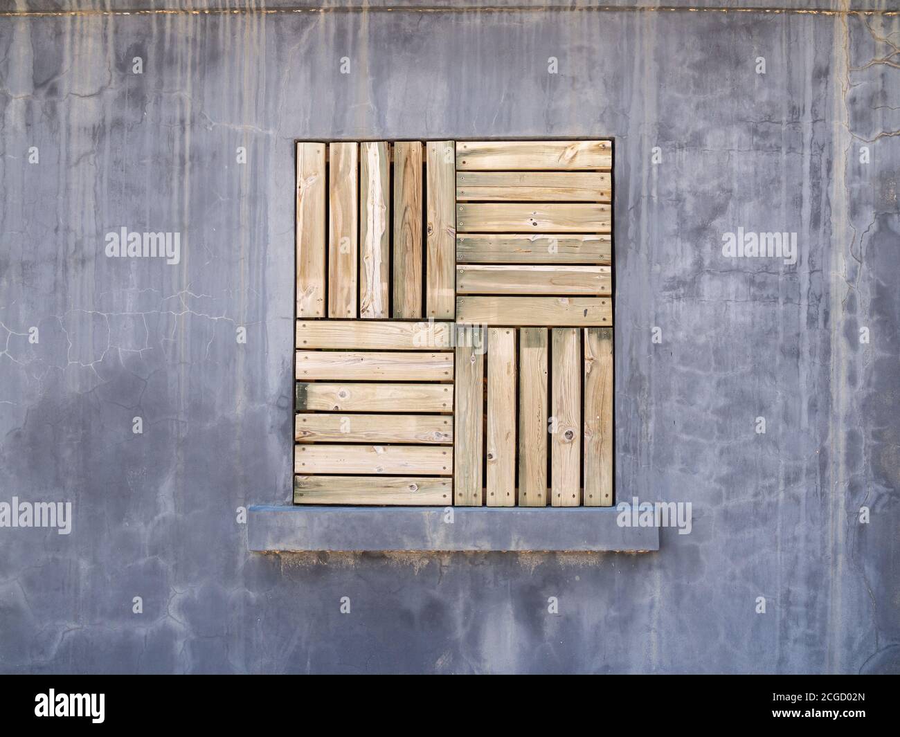 Ancienne fenêtre industrielle avec panneaux en bois dans le gris mur de ciment Banque D'Images