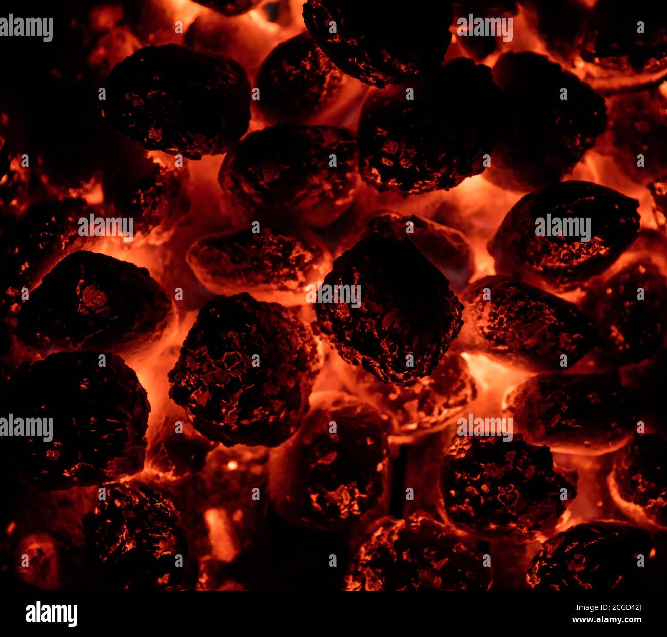 Briquettes de charbon chaud flamboyantes en détail. Texture barbecue, fond de nourriture Banque D'Images