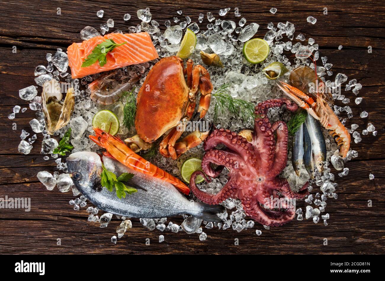 Fruits de mer frais, crabe, moules, crevettes, poisson, crabe, steak de saumon, poisson de bream et autres coquillages servis sur une ancienne table en bois Banque D'Images