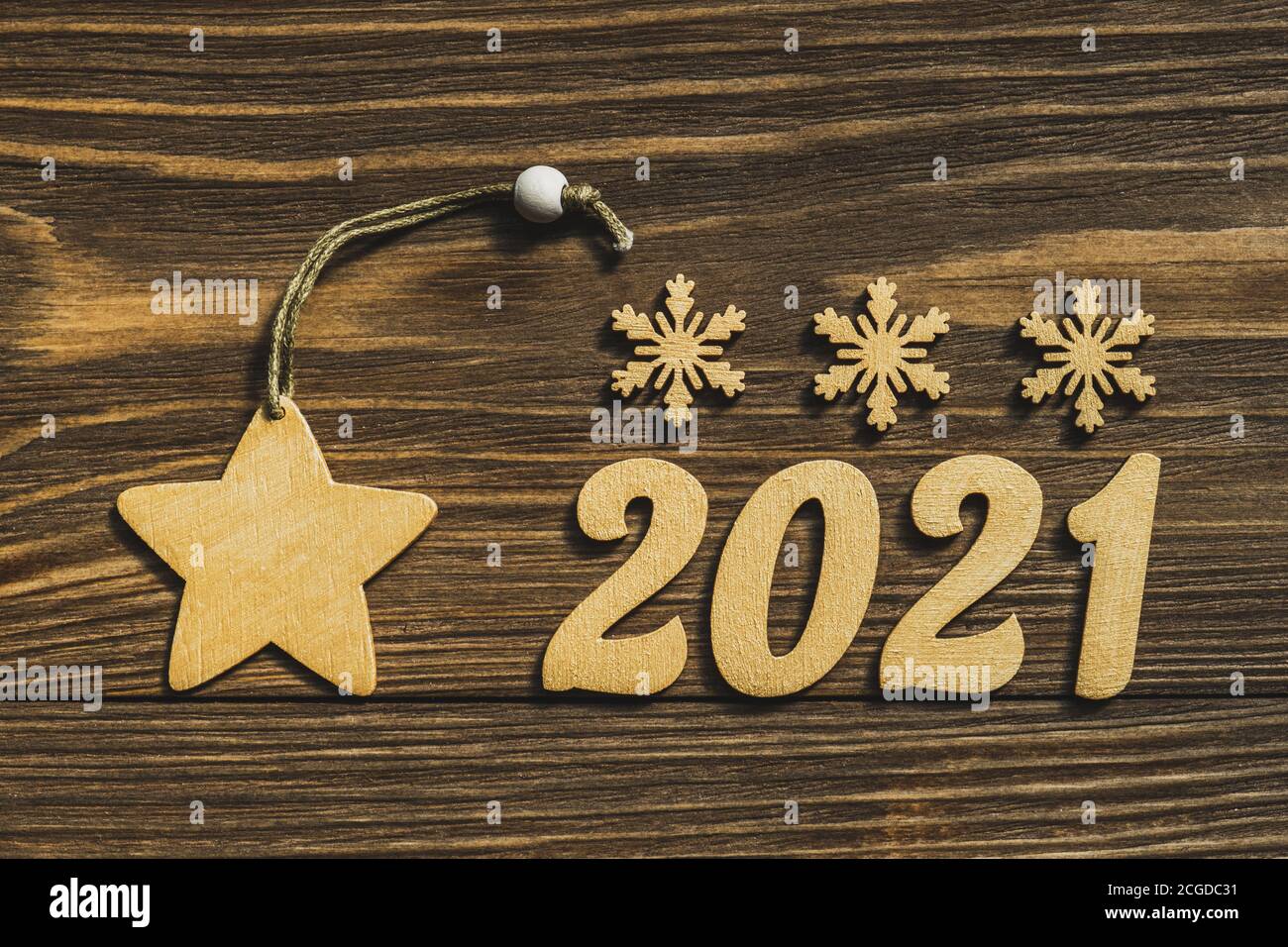 Nouvelle année 2021. Numéros d'or et décorations sous forme d'étoiles et de flocons de neige sur une table en bois sombre. Joyeux Noël et Bonne Année. Copier l'espace Banque D'Images